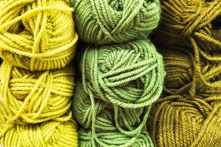 黄色的织品在一家针织和针织品商店的货架上,一团黄色,浅绿色和深绿色
